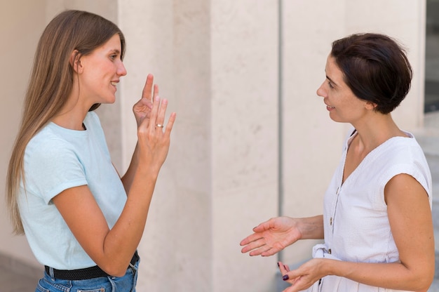 Друзья разговаривают друг с другом, используя язык жестов