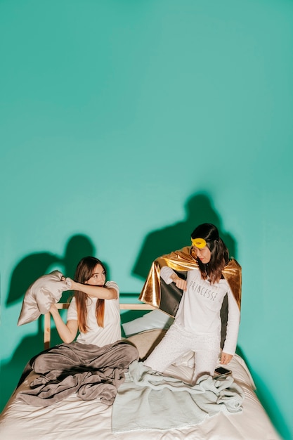 Friends in costumes having pillow fight