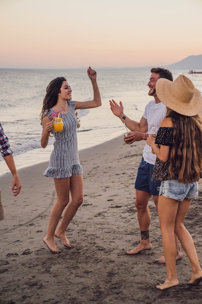 Бесплатное фото Друзья танцуют на пляже на закате