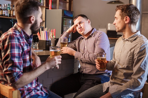 パブのカウンターでビールを飲む友人