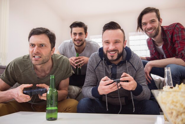 Friends drinking beer and playing videogames