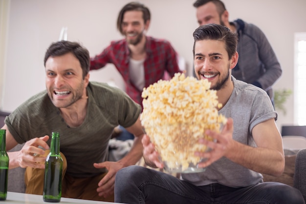 Amici che bevono birra e guardano la partita di calcio