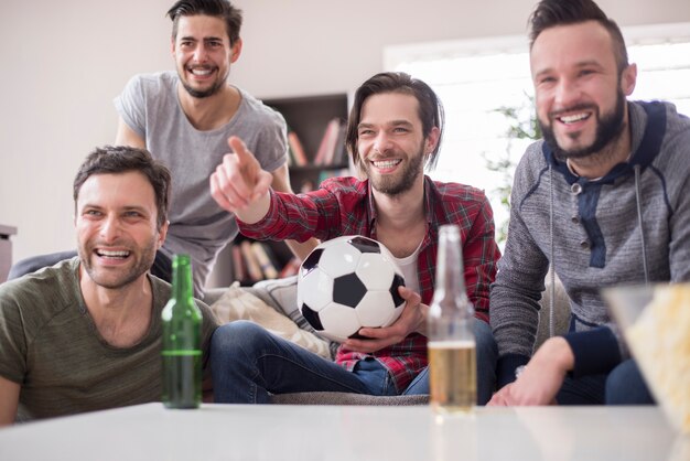 ビールを飲み、サッカーの試合を見ている友達