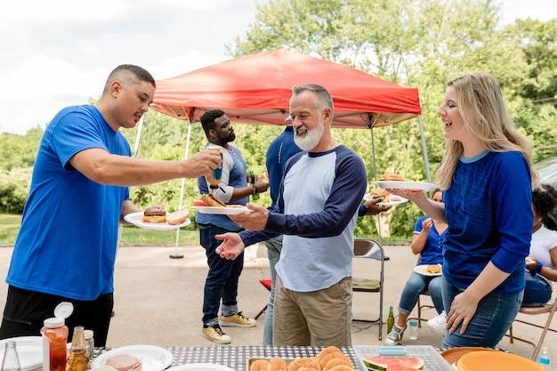 Free photo friends drinking and eating at a tailgate party