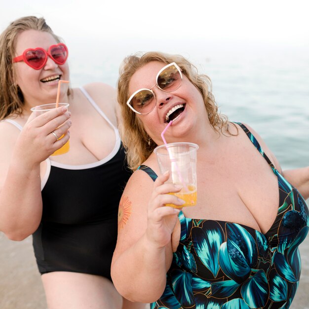 Friends drinking juice at the beach