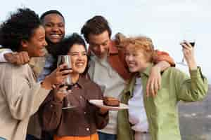 Free photo friends drinking wine and posing during outdoor party