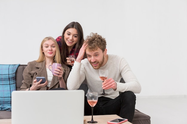 Foto gratuita amici durante il pranzo guardando portatile