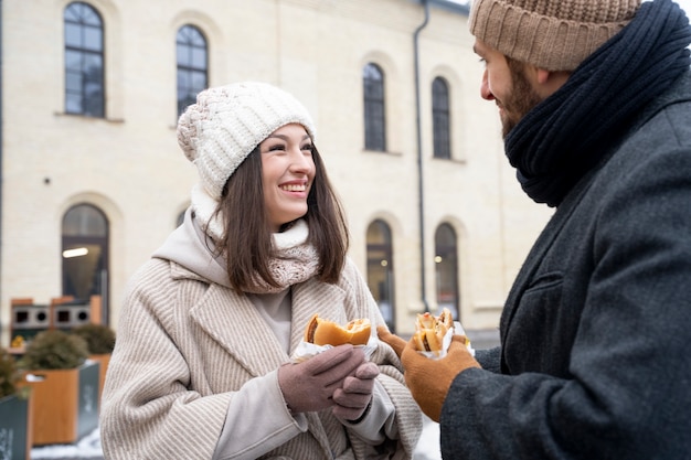 Amici che mangiano hamburger all'aperto dopo essersi riuniti