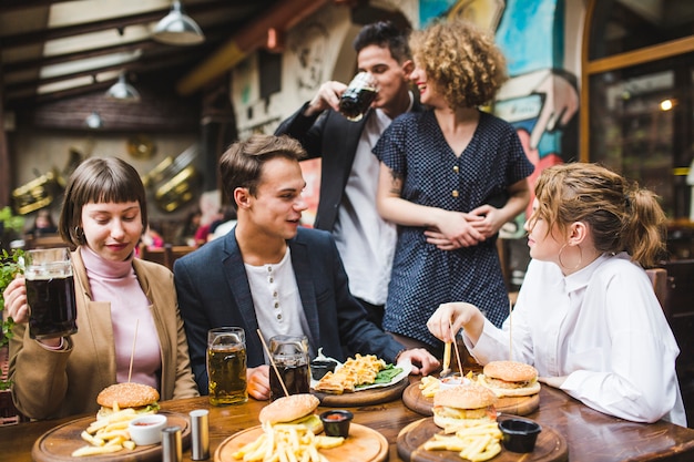 Free photo friends eating and conversating in restaurant