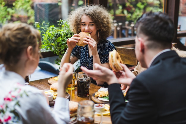 Free photo friends eating and conversating in restaurant