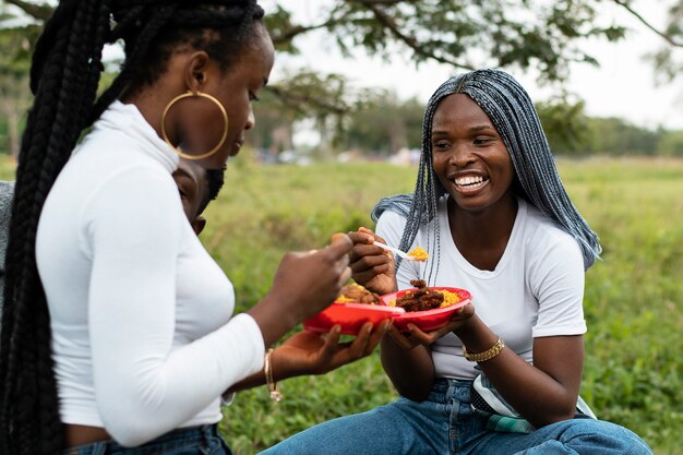 Friends eating lunch outdoors medium shot