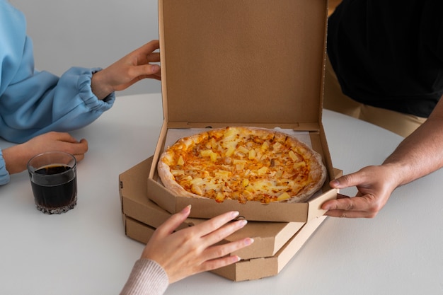 Friends eating pizza at home together