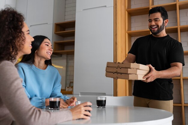 Friends eating pizza at home together