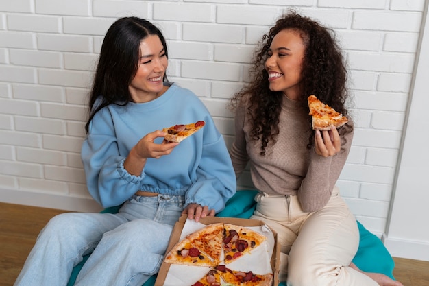 Друзья вместе едят пиццу дома