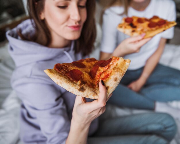 家でピザを食べている友達