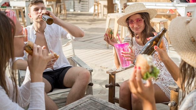 Friends enjoying burgers outdoors together with drinks