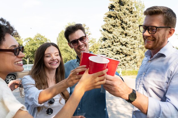 プラスチック製のコップから飲み物を楽しんでいる友達