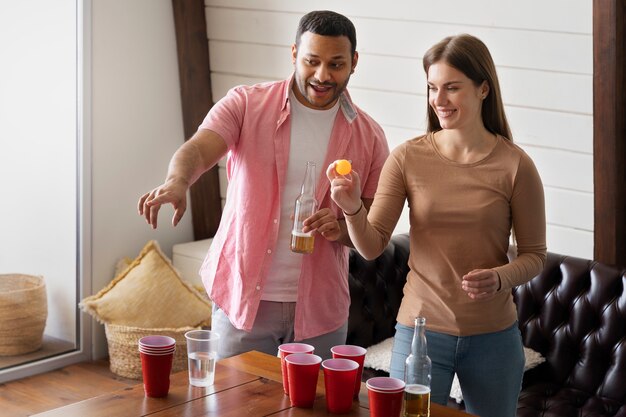 Friends enjoying a game of beer pong at an indoor party