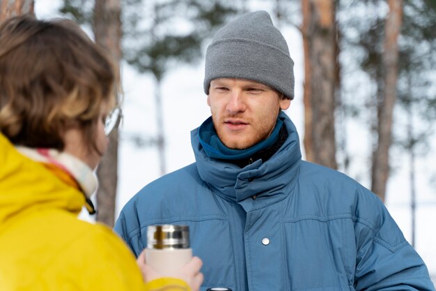 冬の旅行中に温かい飲み物を楽しんでいる友達