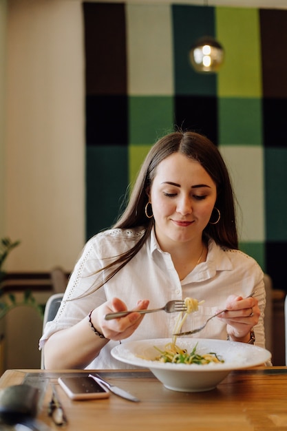 Amici che godono del pranzo al ristorante, mangiando pasta