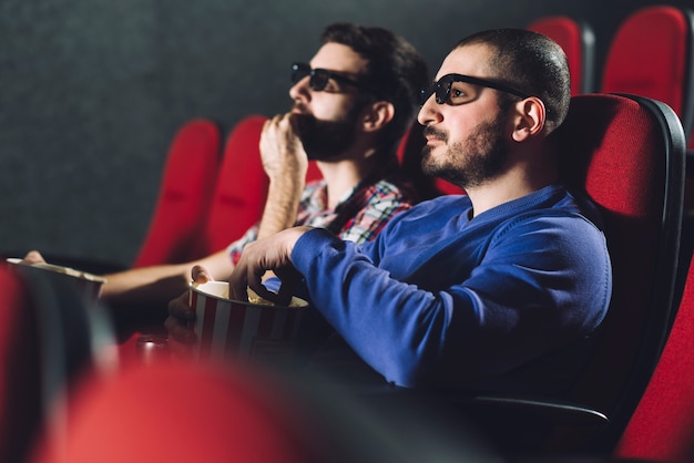 Free photo friends enjoying movie in cinema