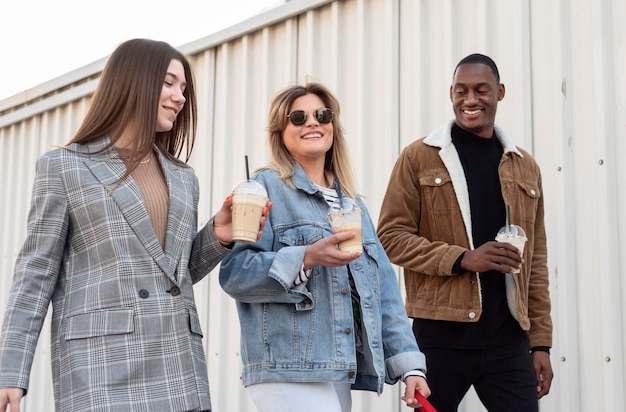 Amici che vanno in giro gustando una tazza di caffè