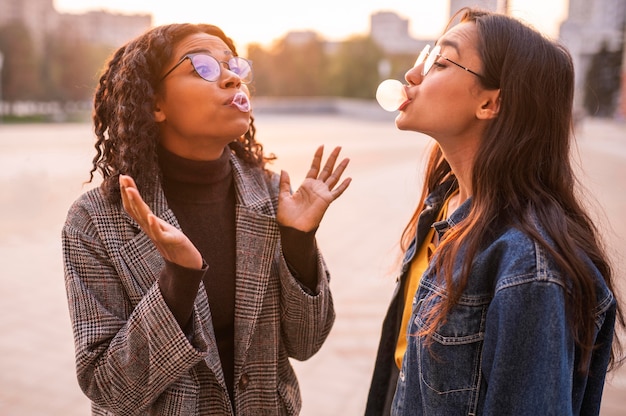 Free photo friends having fun blowing bubbles outdoors