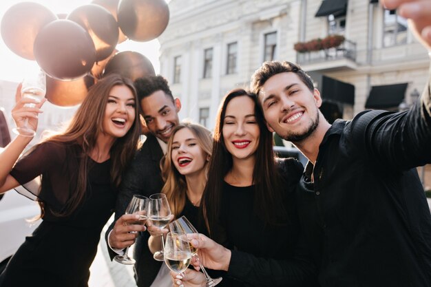 Friends having fun and drinking champagne outdoors