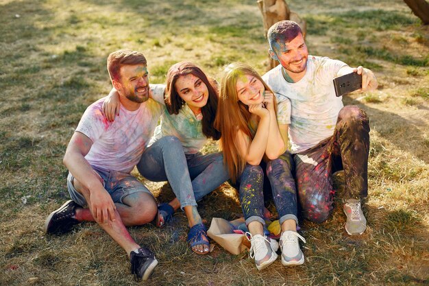 friends having fun in a park with holi paints