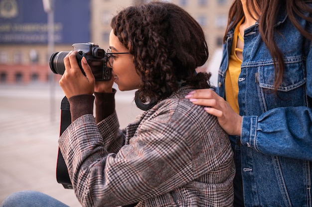 Foto gratuita amici che si divertono insieme fuori con la macchina fotografica