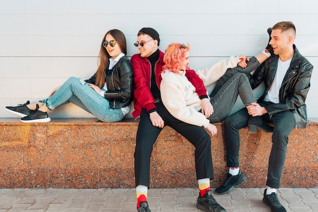 Friends having fun while leaning on street bench