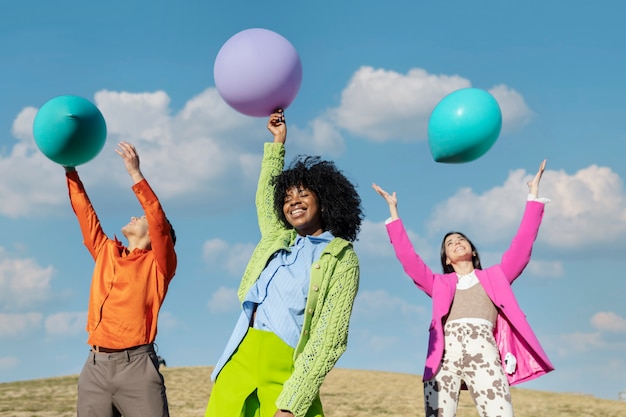 Free photo friends having fun with balloons in an outdoor field