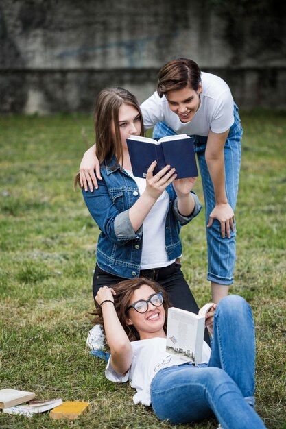 Friends having fun with books in park