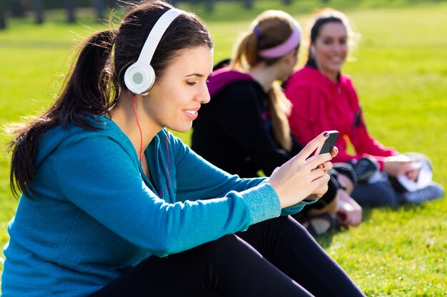 Friends having fun with smartphones after exercise