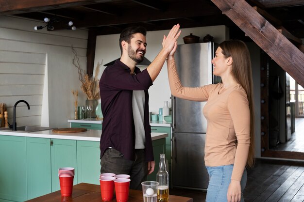 Friends high-fiving each other over a beer pong game
