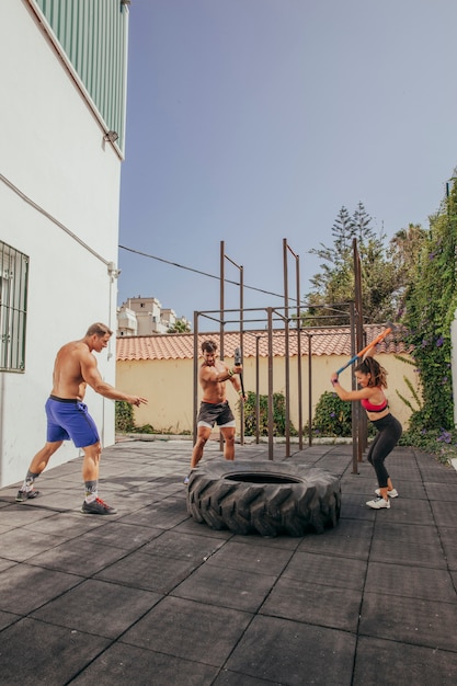 Free photo friends hitting wheel with hammer