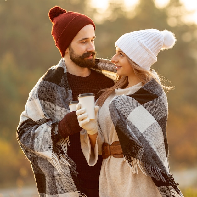 Friends holding cups of coffee while looking at each other