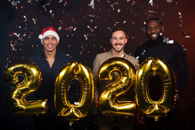 Friends holding golden balloons for new years