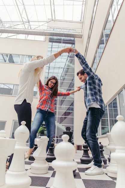 Free photo friends holding hands on chess board