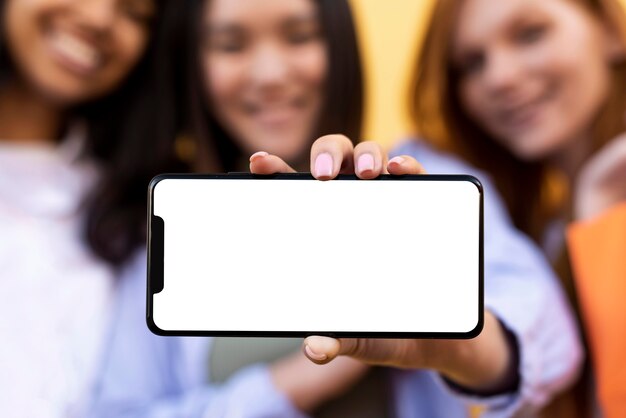 Friends holding shopping bags and a blank phone