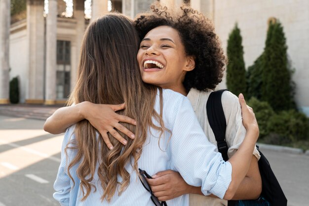 Friends hugging after seeing each other outdoors