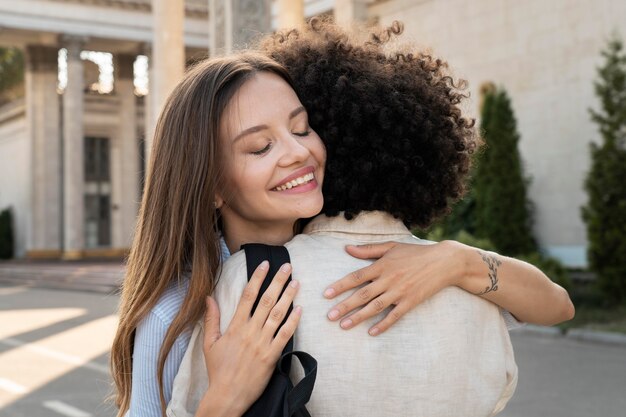 屋外でお互いを見た後に抱き合う友達