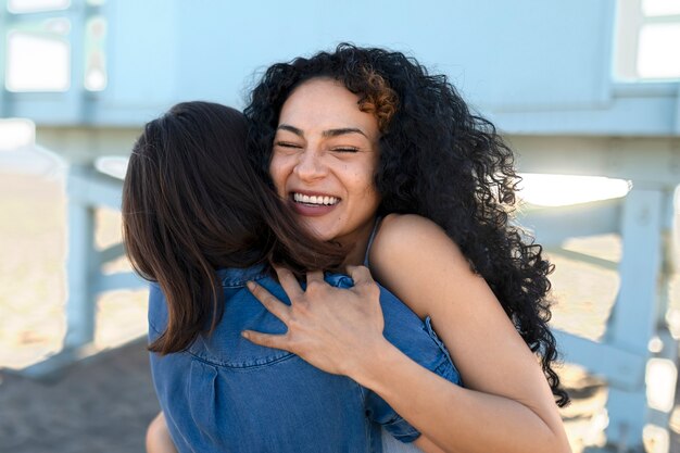 Friends hugging by the sea shore