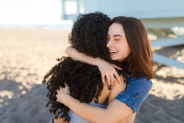 Friends hugging by the sea shore