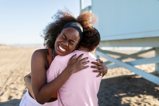 Friends hugging by the sea shore