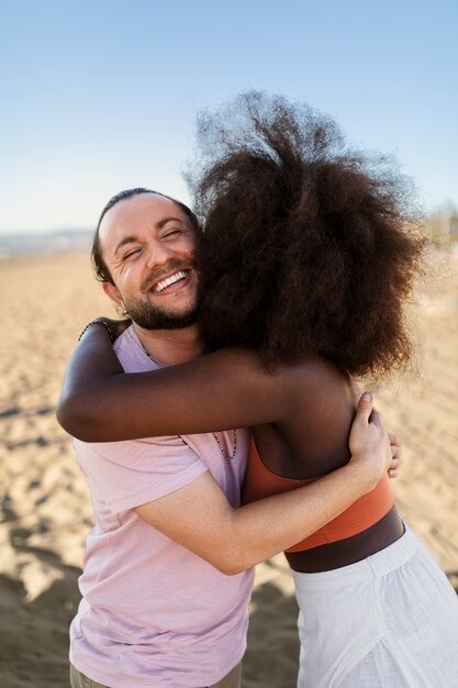 Friends hugging by the sea shore