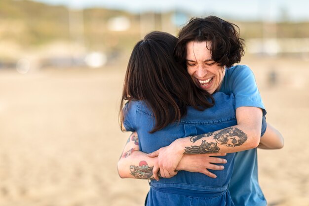 Friends hugging by the sea shore