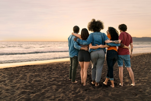 Free photo friends hugging by the sea shore