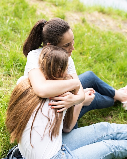 Friends hugging and sitting on the grass