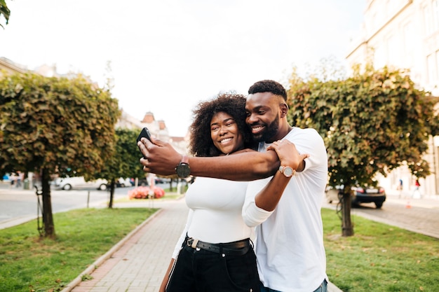 Foto gratuita amici che abbracciano e che prendono selfie